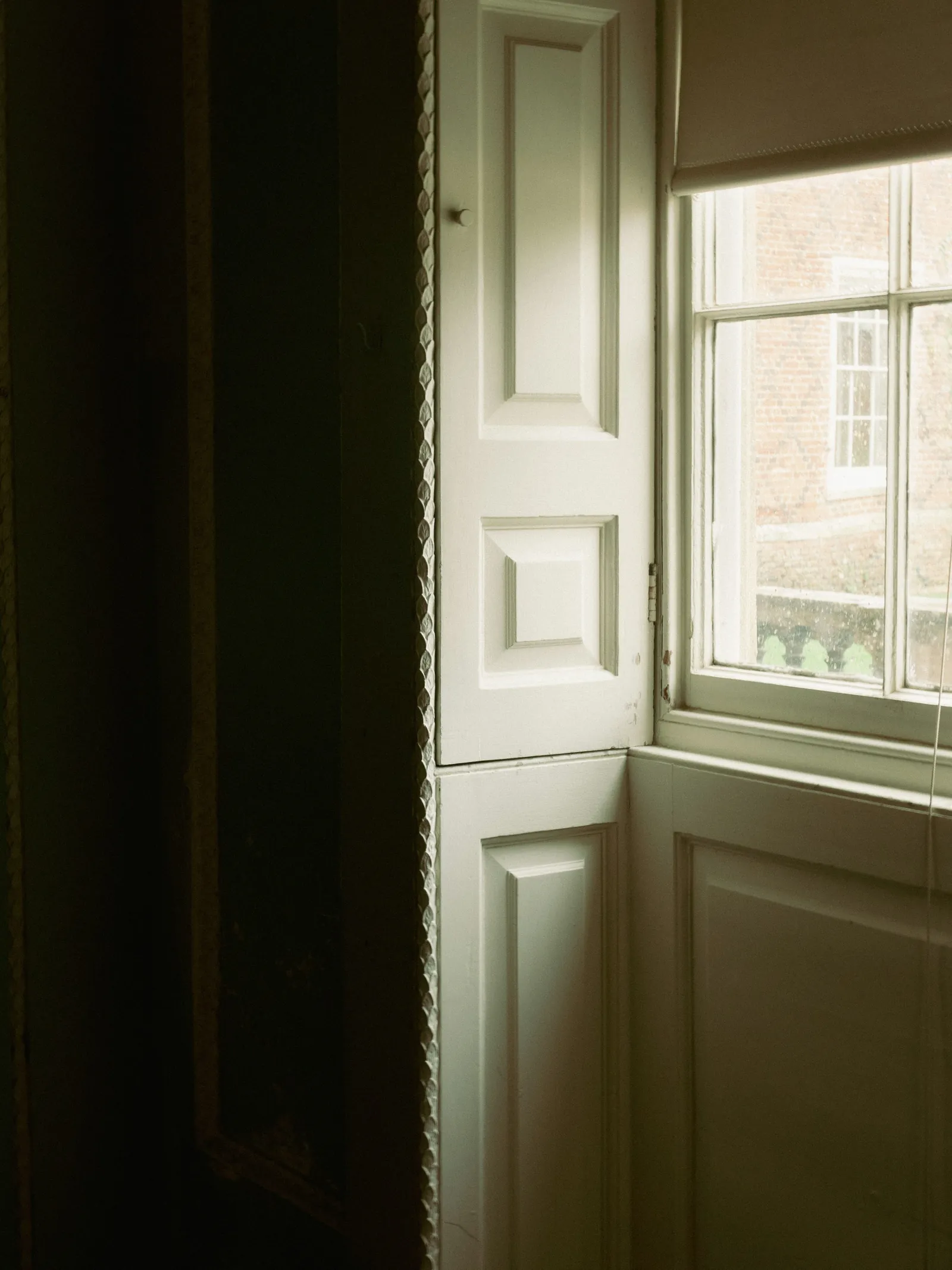 Folded timber shutters beside a tall sash window