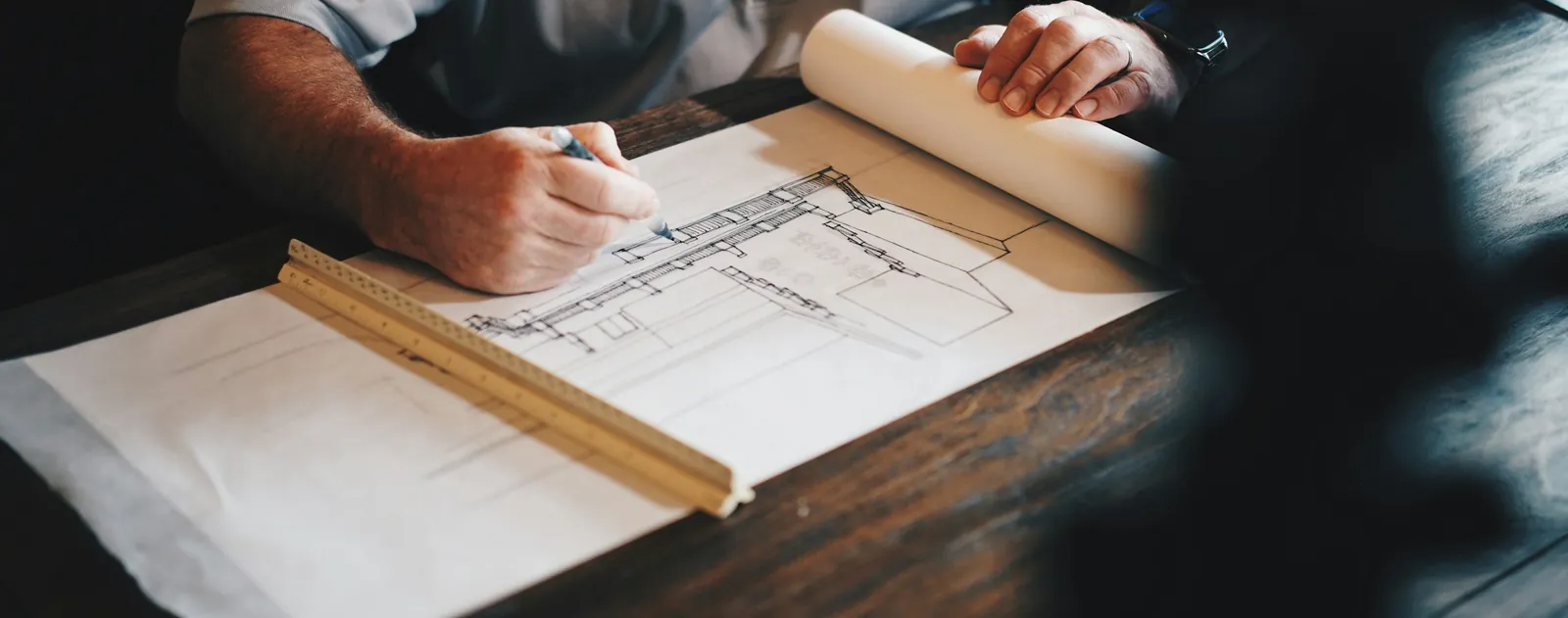 A hand drawing on a plan with a scale rule