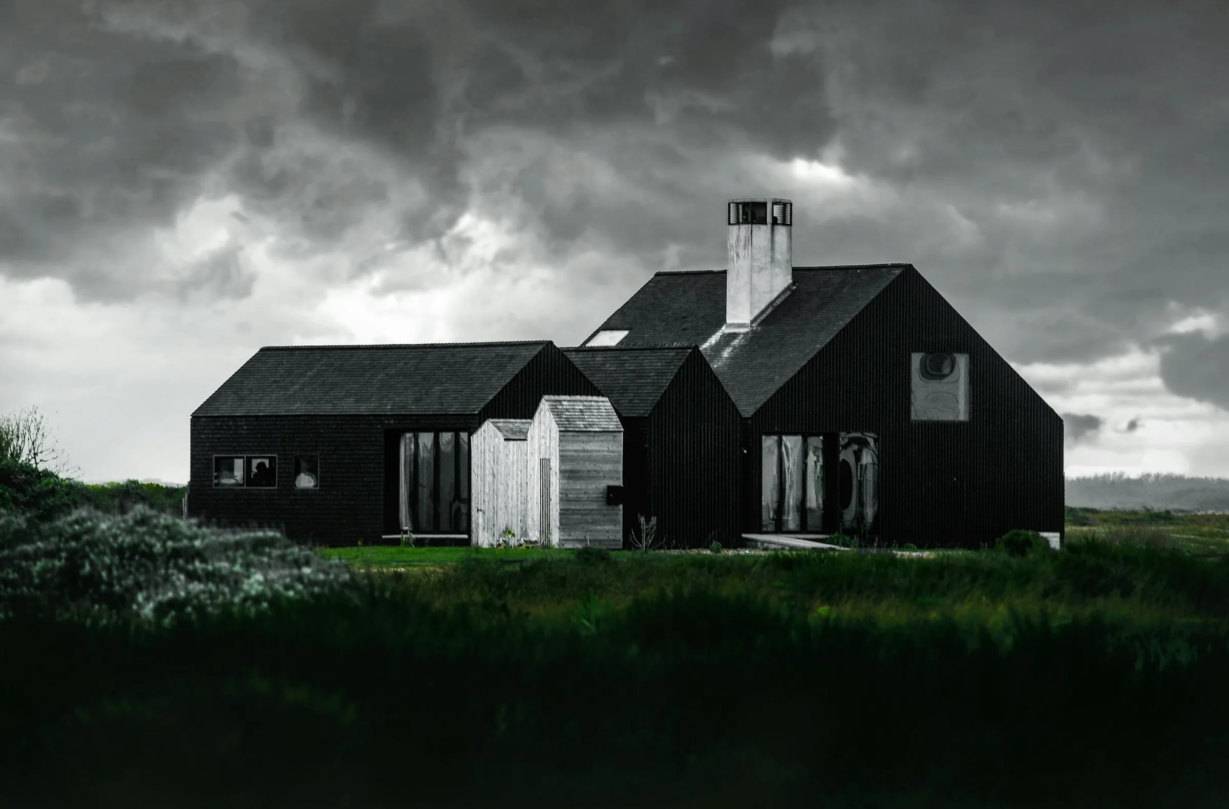 Hartington House: three black timber roofs clustered in open moorland under a heavy sky