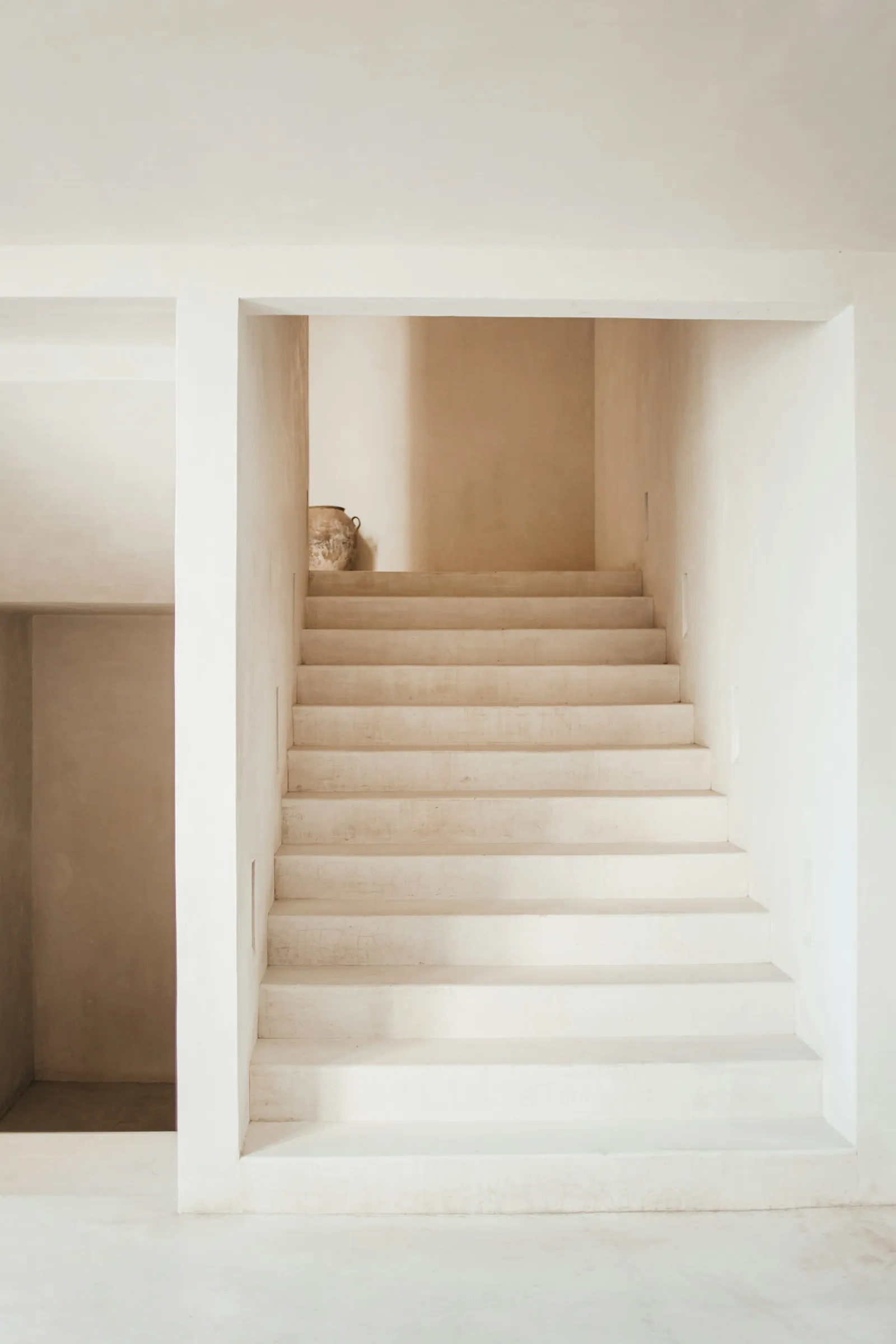 A plaster stair turning up towards a rooflight