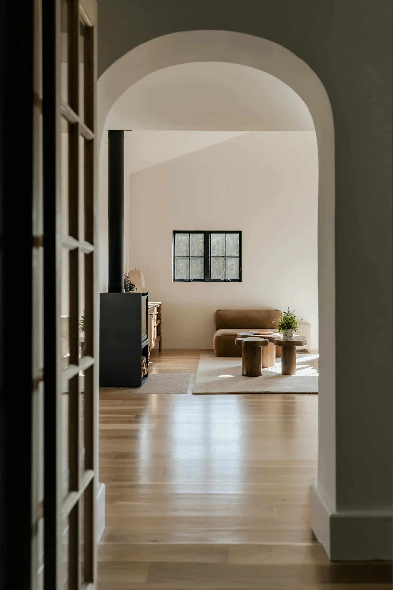 An arched opening in the hall looking through to the living room