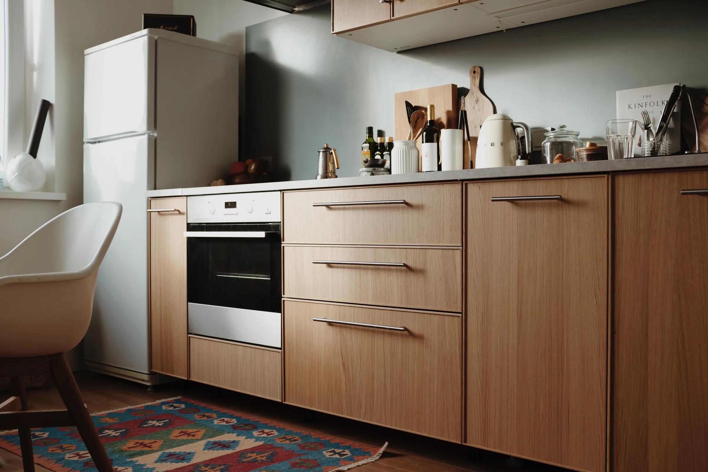 Wollaton Kitchen: oak-fronted units with a stone worktop and a single long shelf