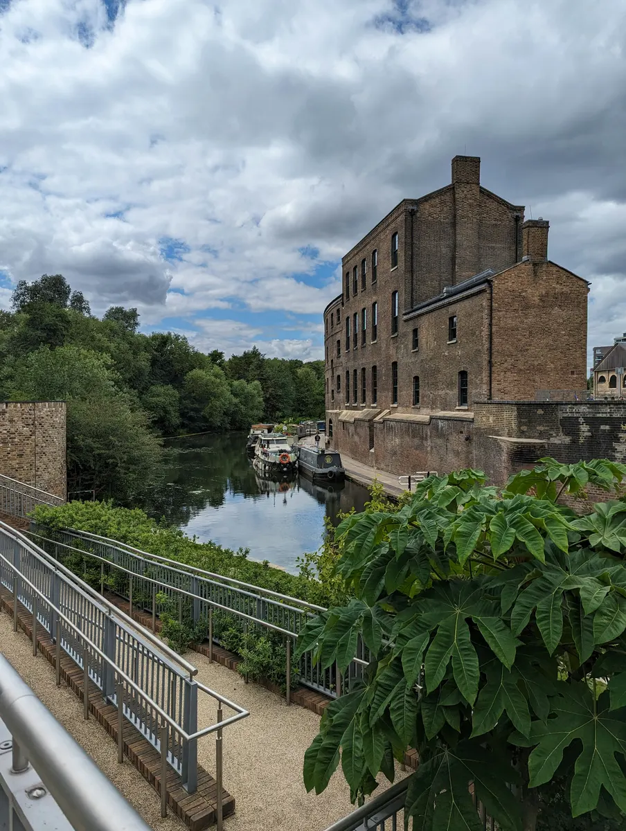 A canal-side mill building in red brick beside a lock