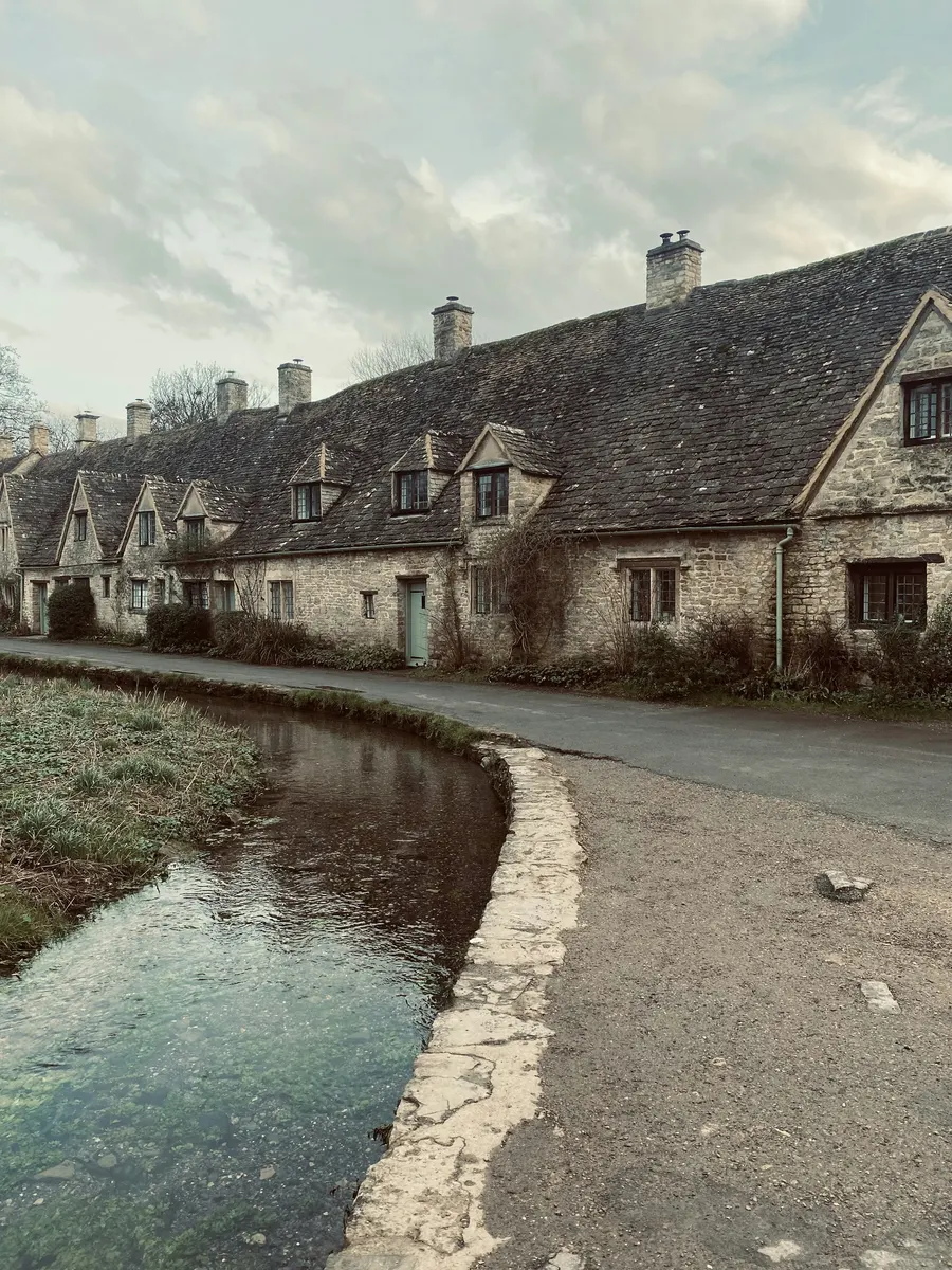 Stone cottages beside a shallow river in a village