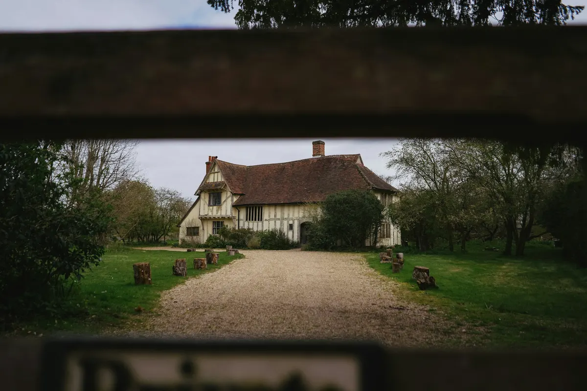 A farmhouse at dusk with its lights on