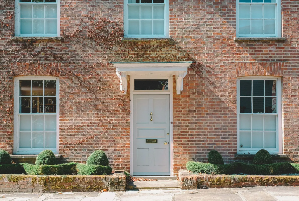 A brick Georgian frontage with a white panelled door
