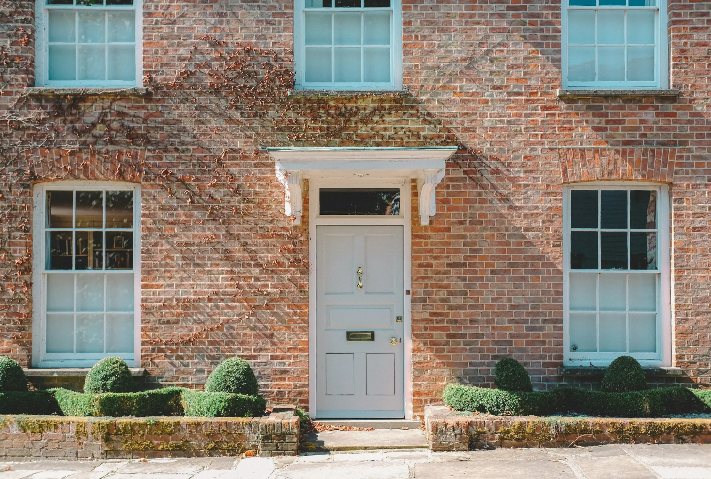 A brick Georgian frontage with a white panelled door