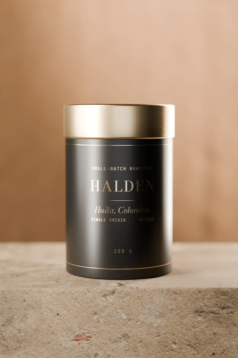 The black Huila tin with a brass lid on a stone plinth