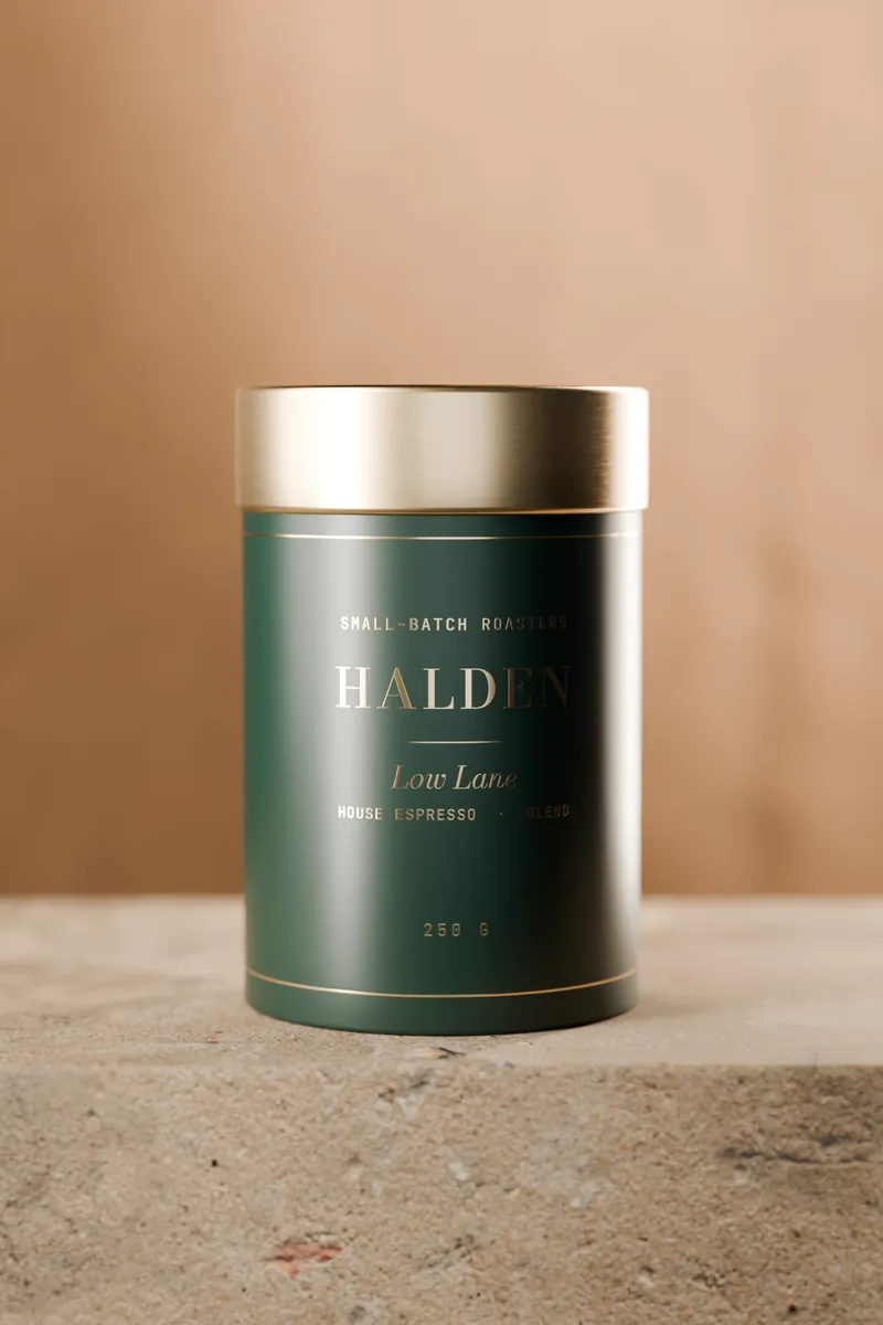The bottle-green Low Lane tin with a brass lid on a stone plinth