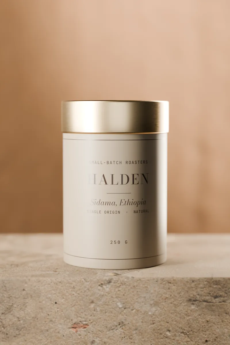 The cream Sidama tin with a brass lid on a stone plinth