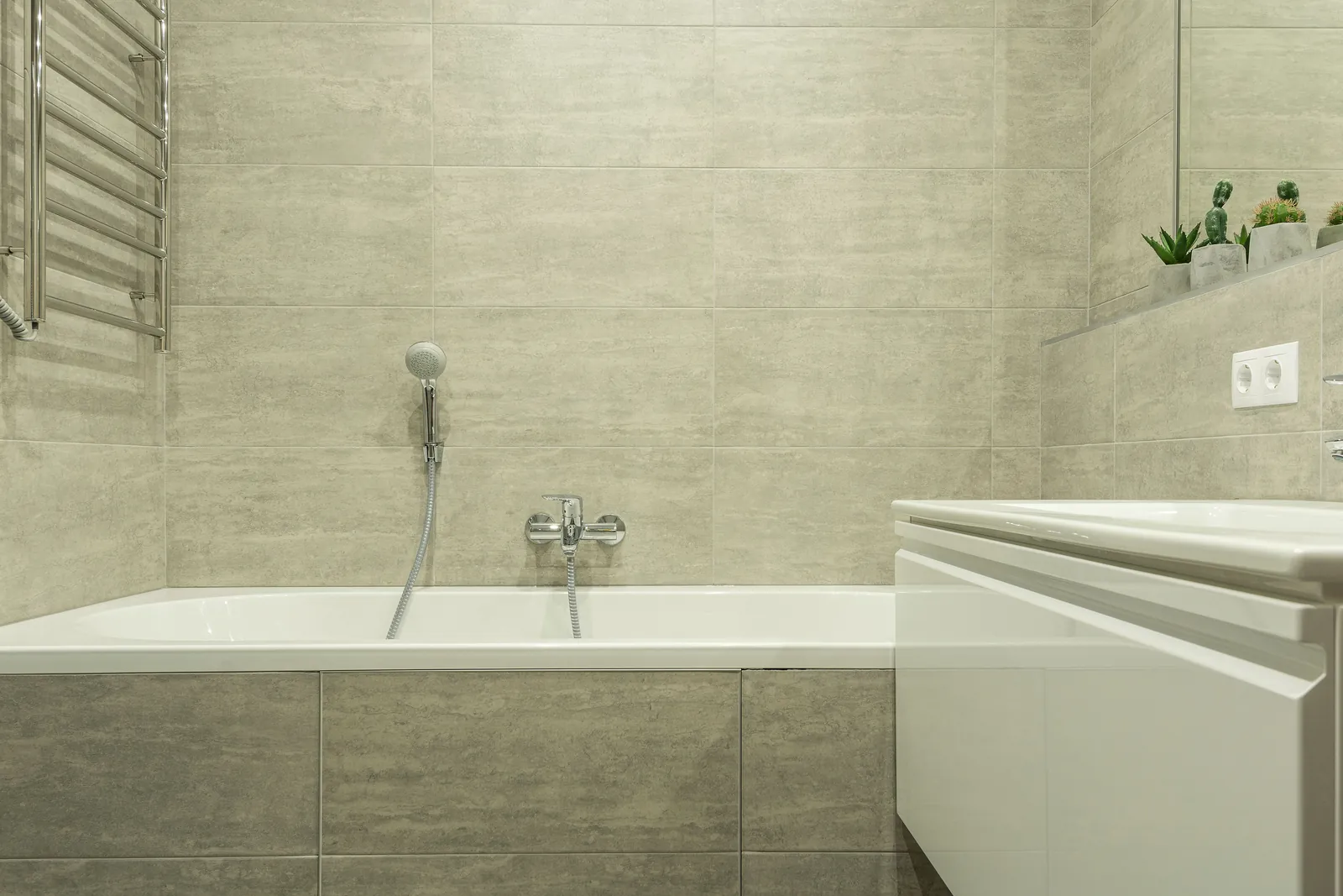 A bath and shower screen with stone-effect tiling