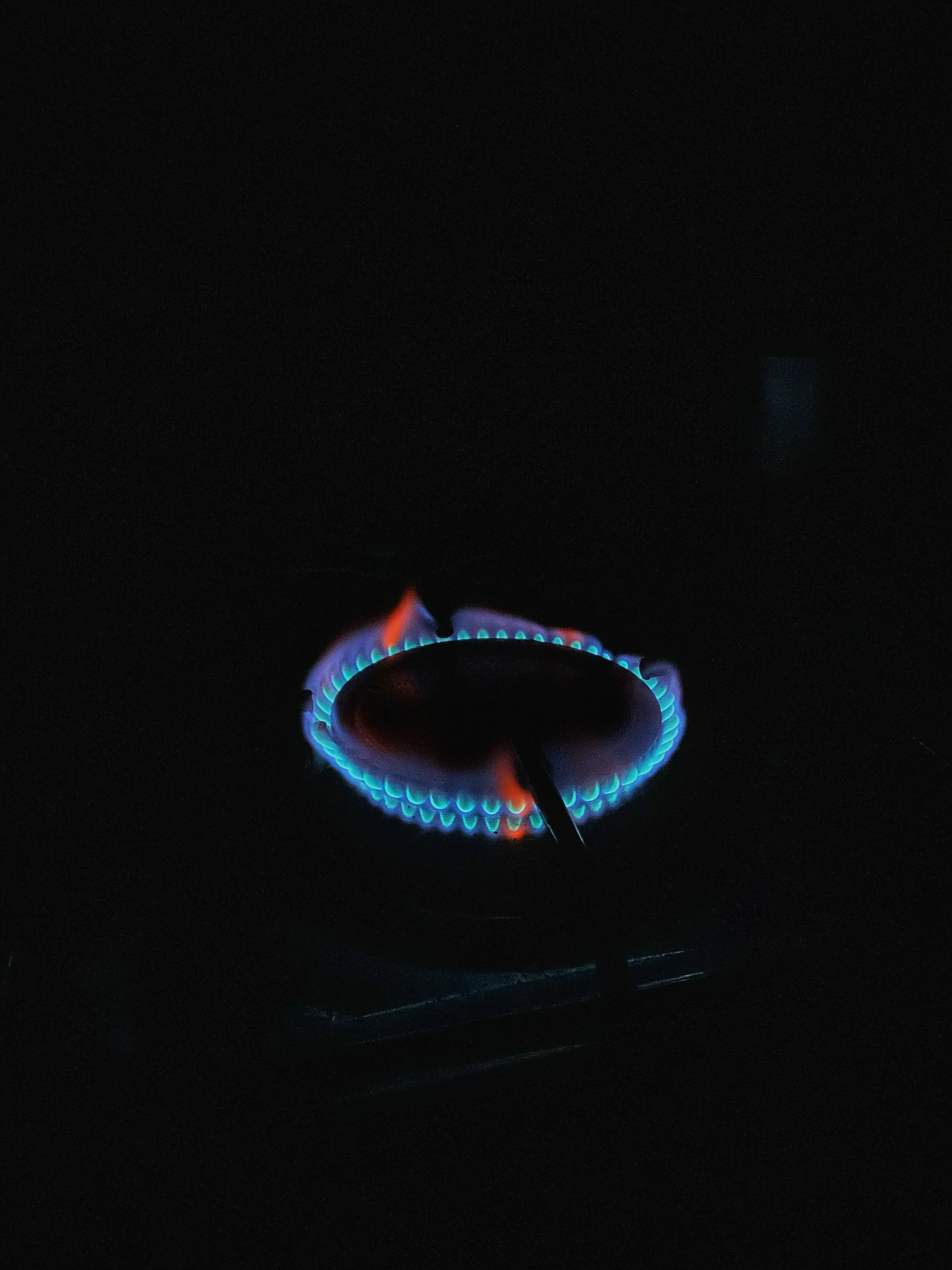 A blue gas ring burning in the dark