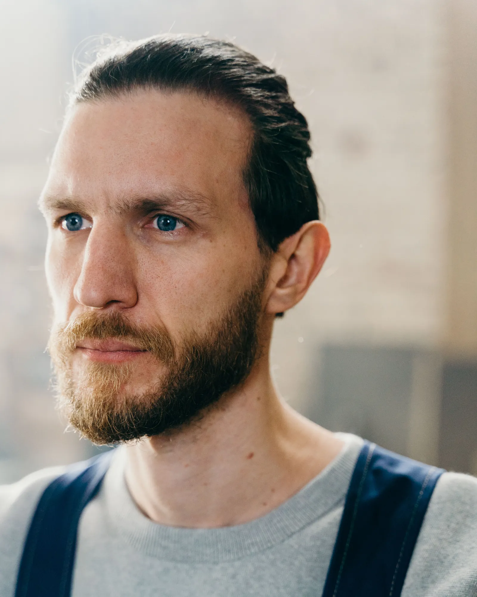 Marcus, a bearded plumber in dungarees, photographed indoors