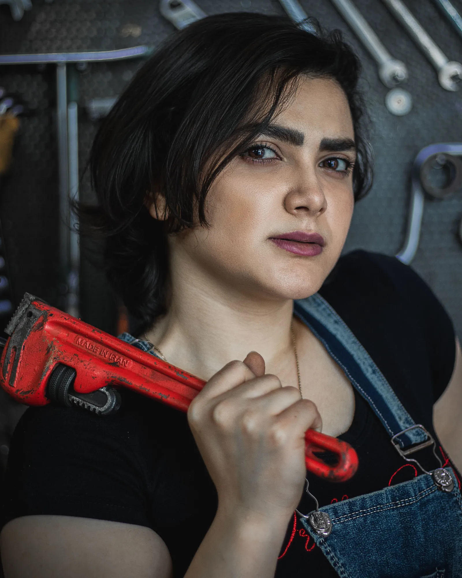Priya, a heating engineer with a pipe wrench over her shoulder in the workshop