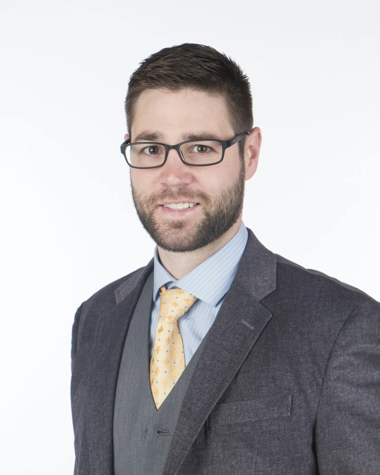 Daniel Pike in a grey suit and tie, photographed against a plain background