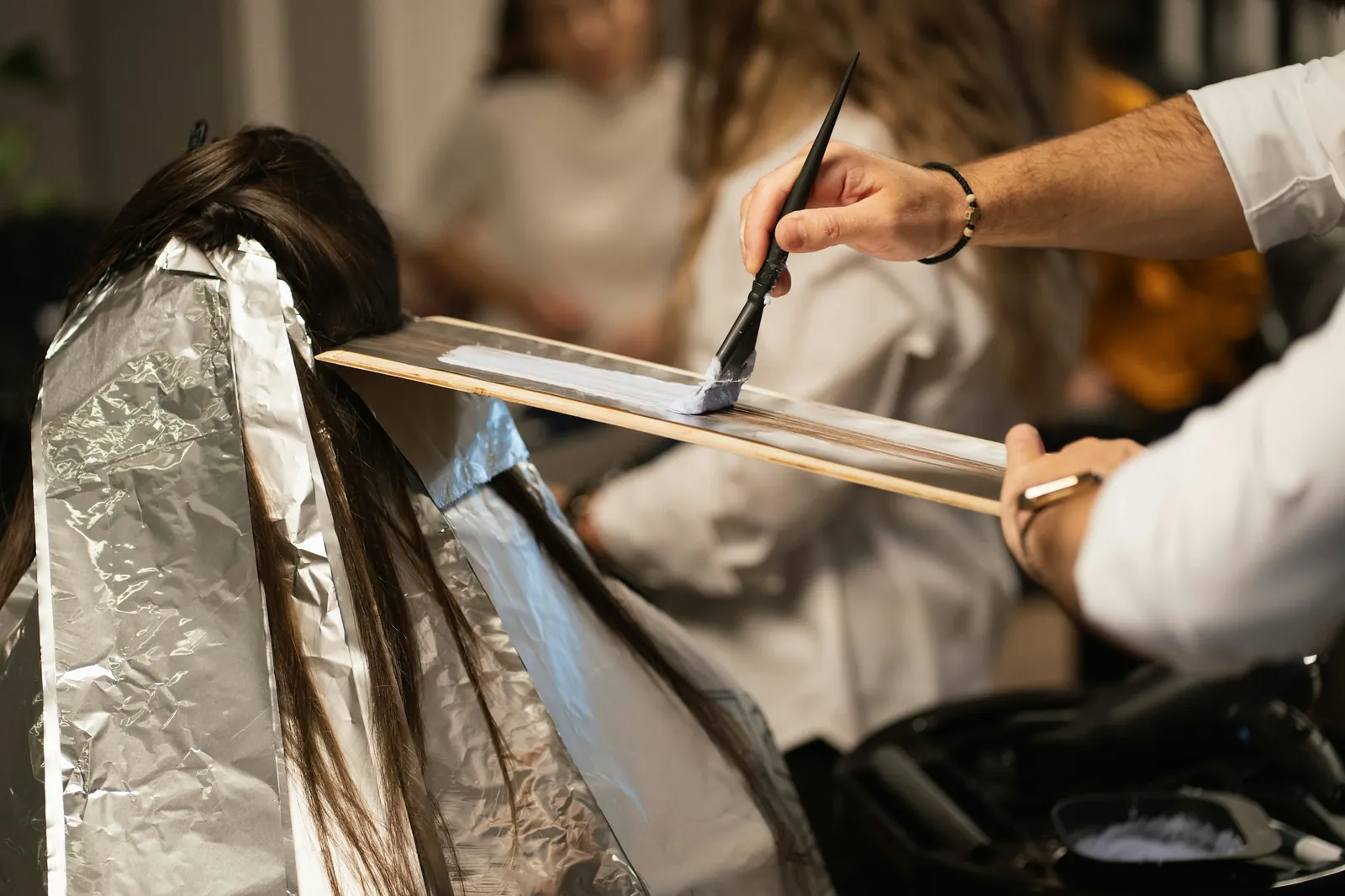Foils being folded into dark hair