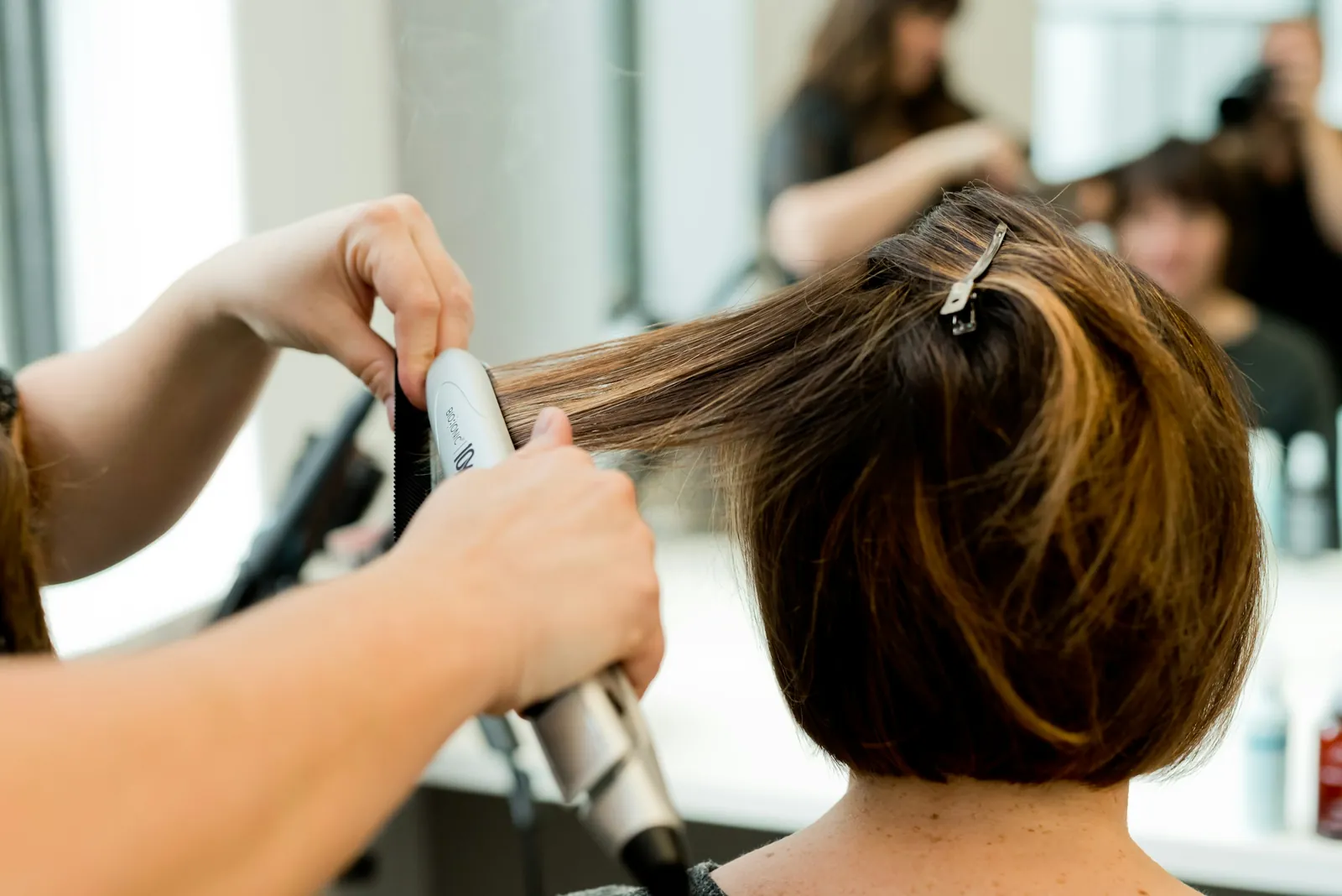 A round brush and dryer finishing a dark-blonde bob