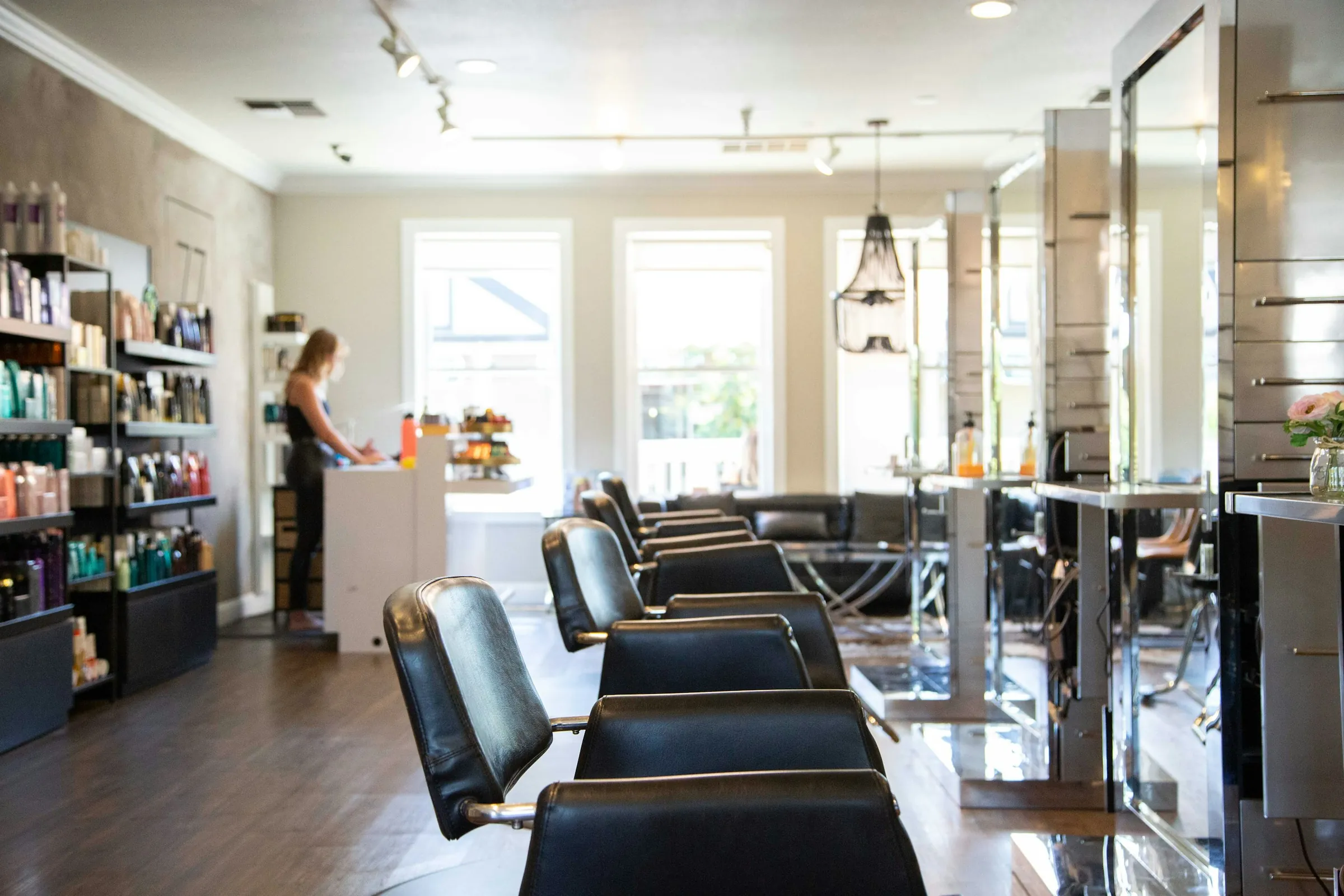 A row of chairs and mirrors under the salon windows