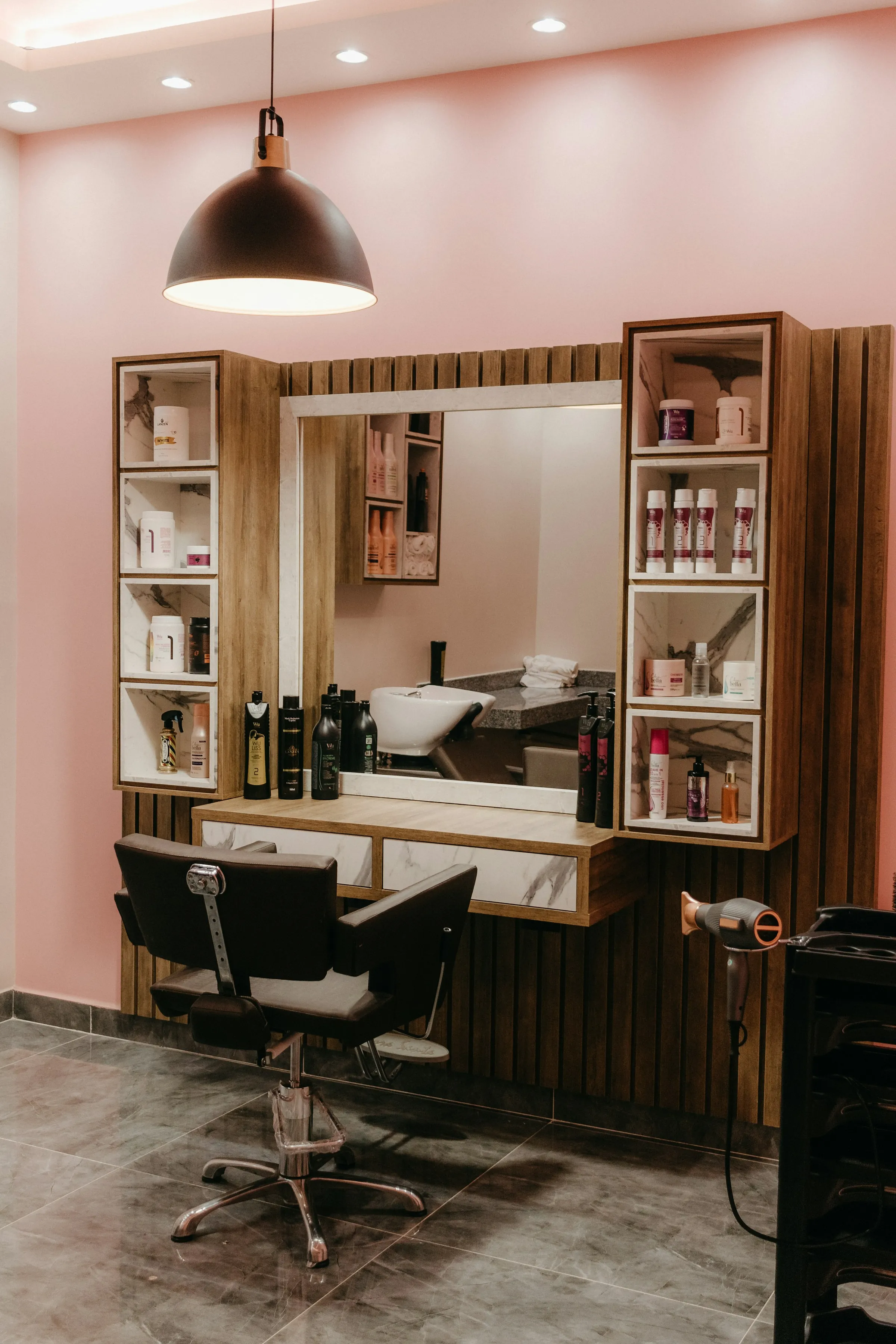 The chair and mirror by the blush wall at the front of the salon