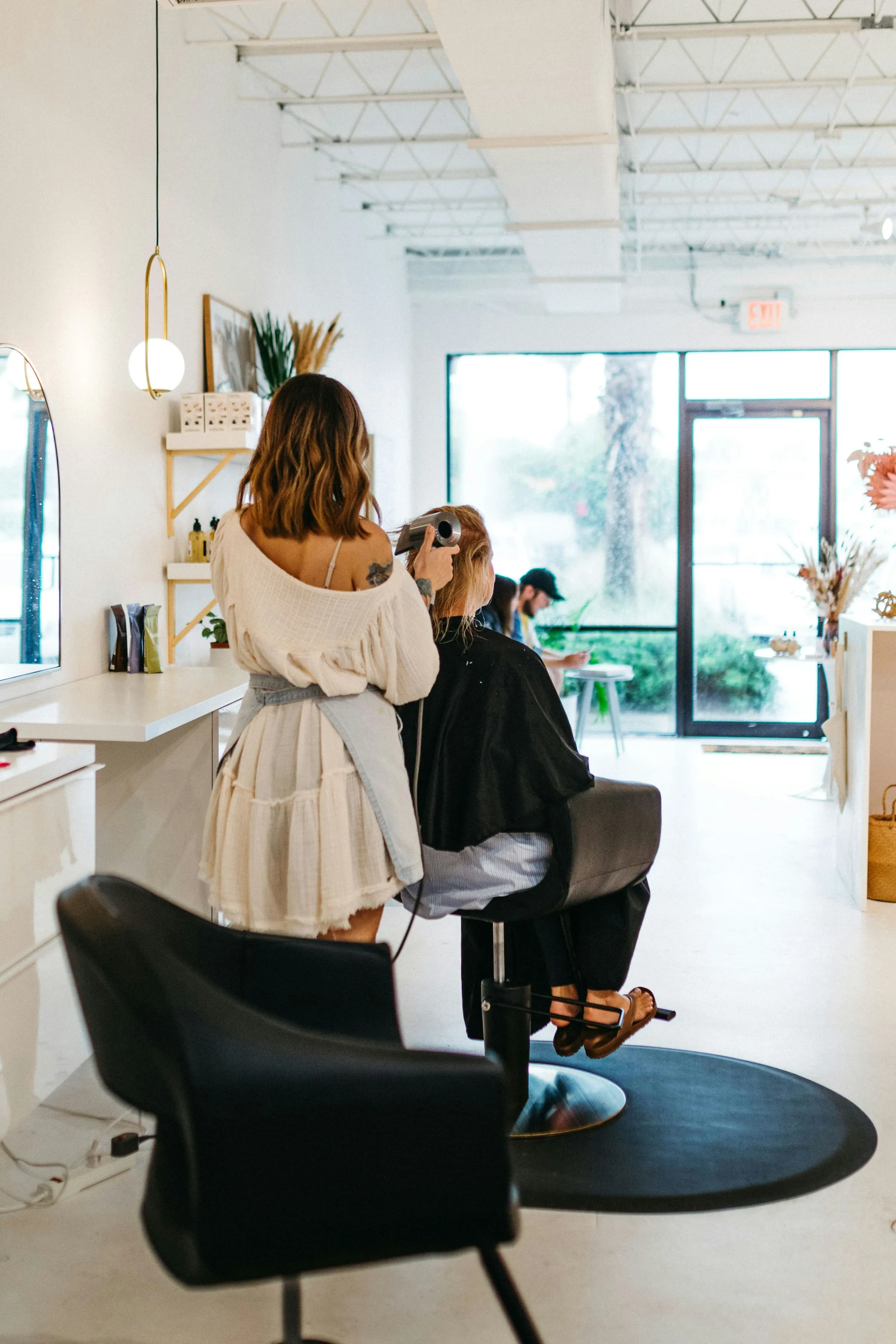 A stylist at work by the salon window