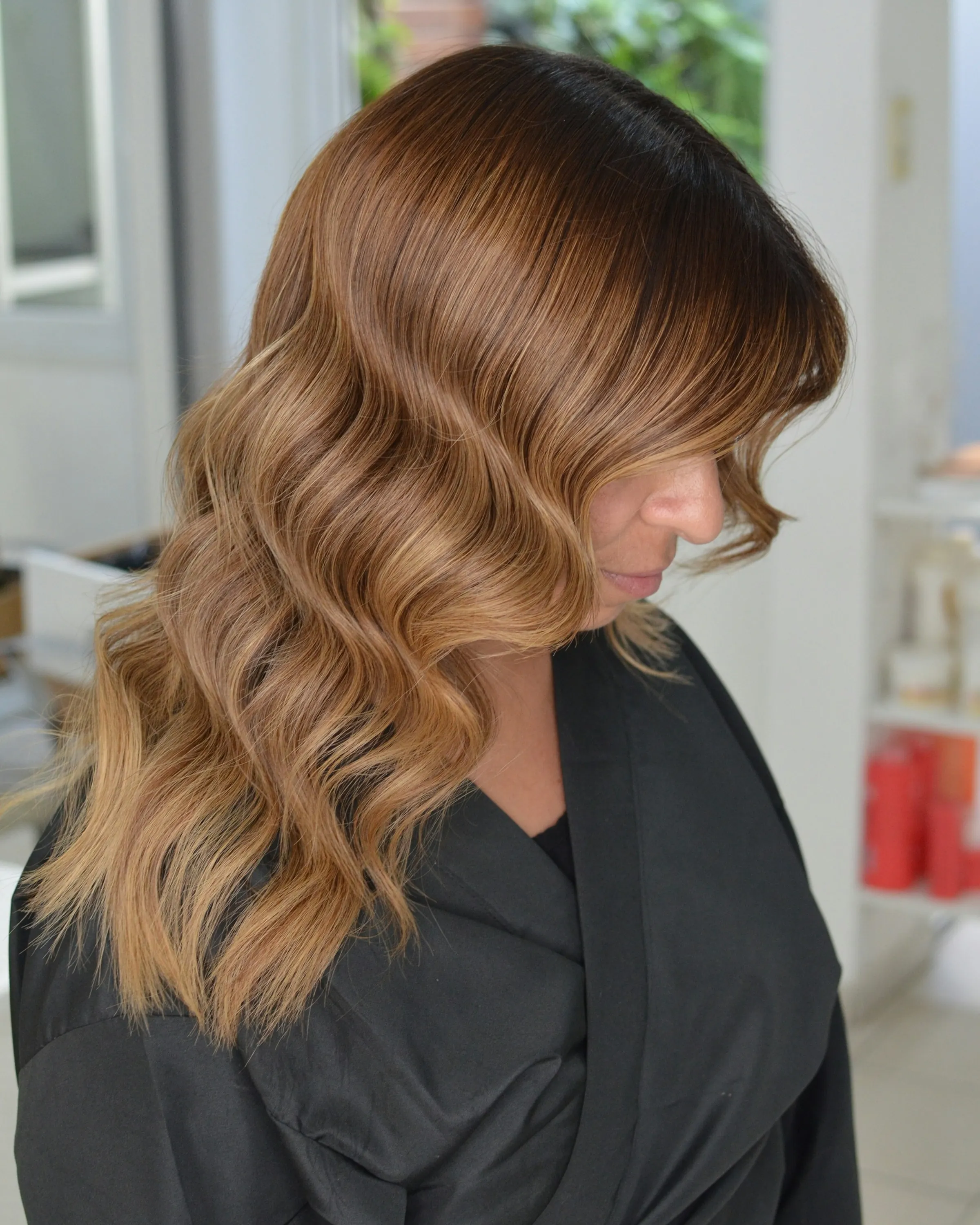 Caramel balayage finished in soft waves, side view