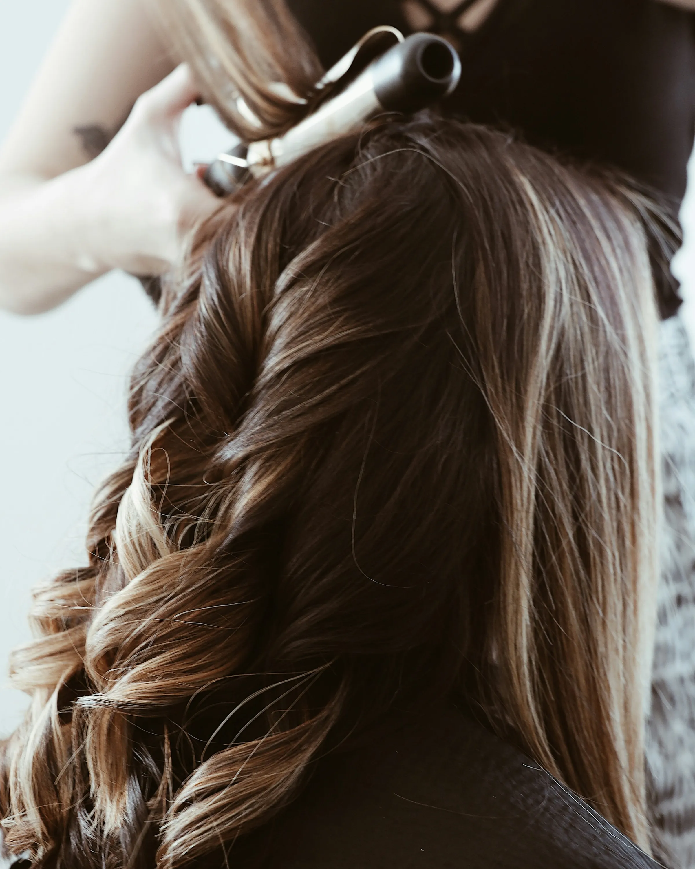 Dark-blonde balayage finished in bouncy waves from behind