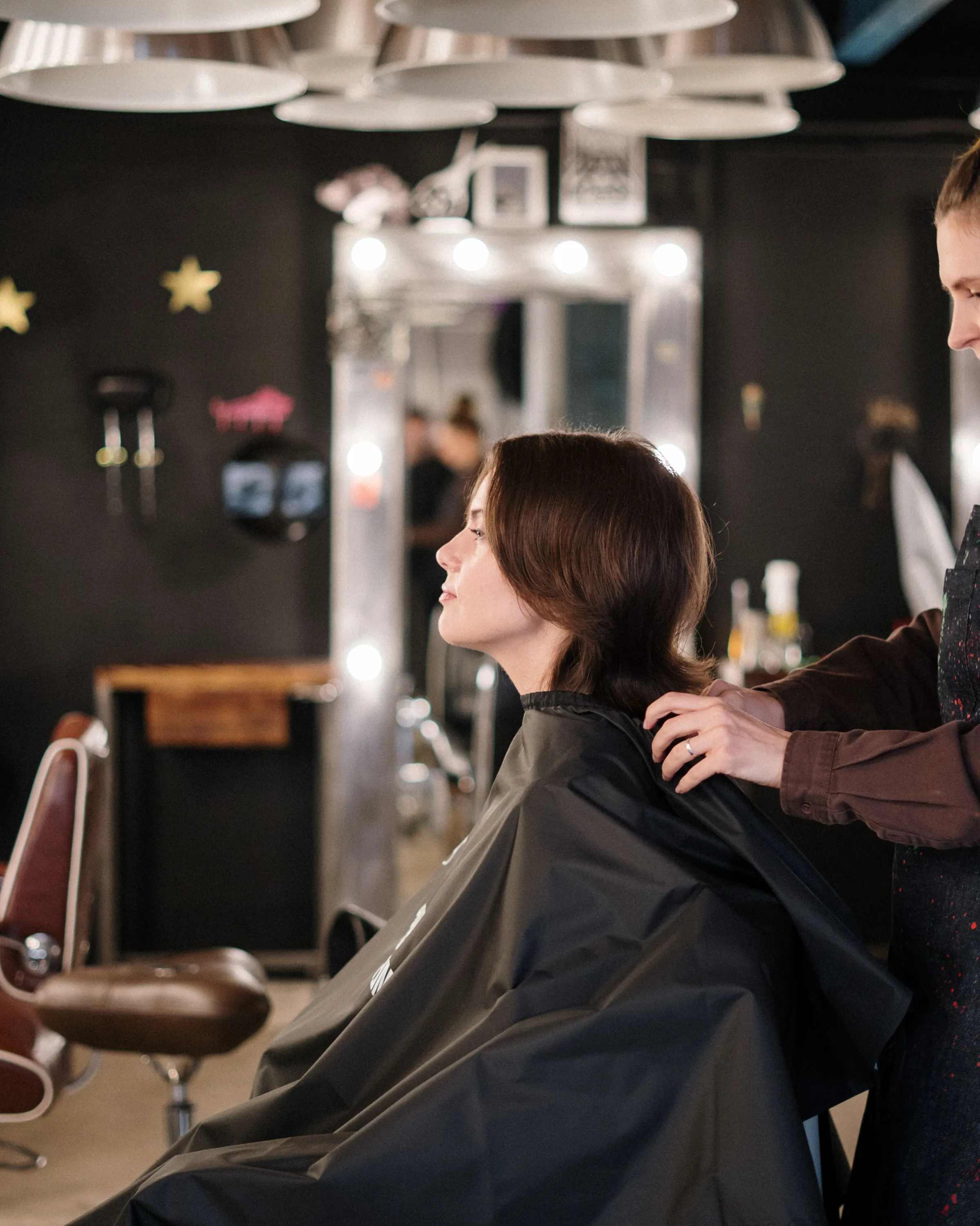 The finished dark gloss, a stylist settling the cape