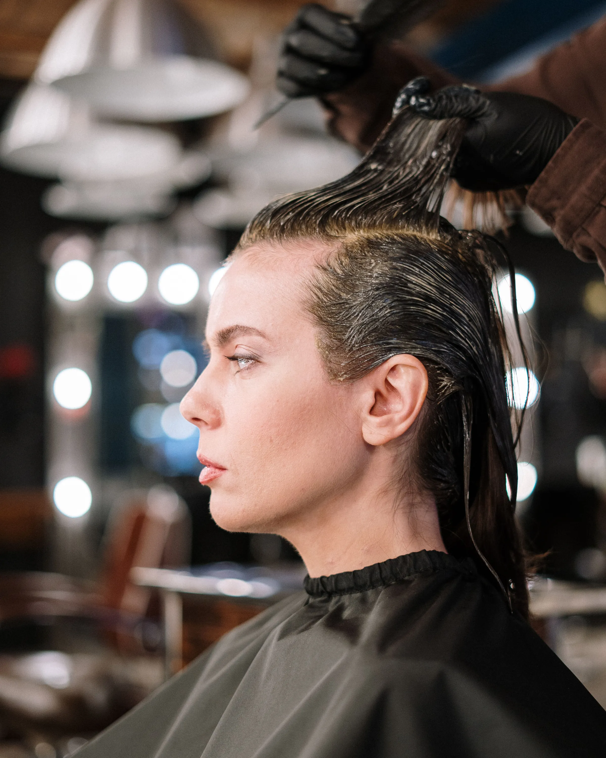 Colour being worked through the roots with gloved hands, side profile