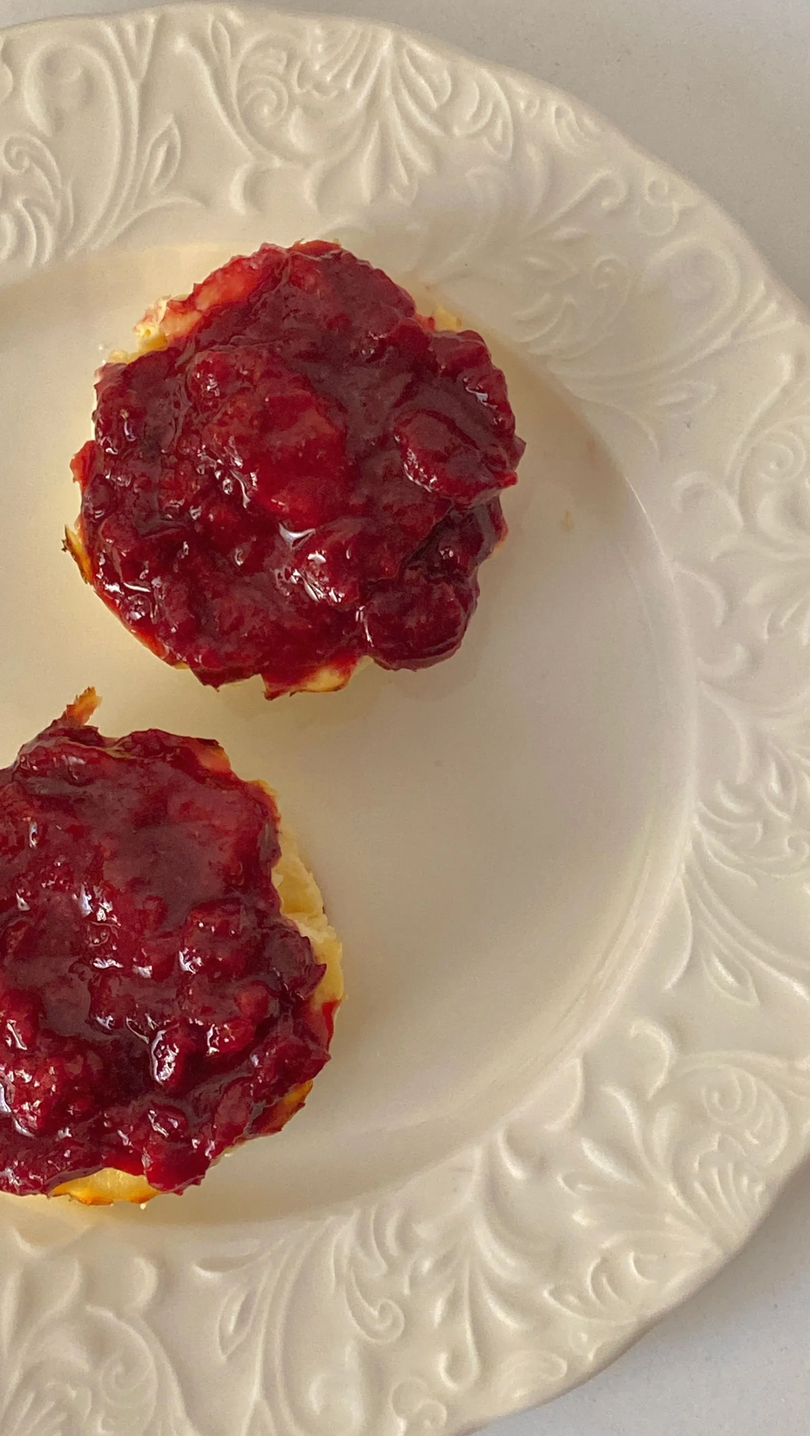 A scone with jam on a white plate