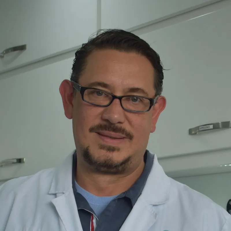 Dr Marek Nowak, a man in glasses and a white clinical coat, smiling