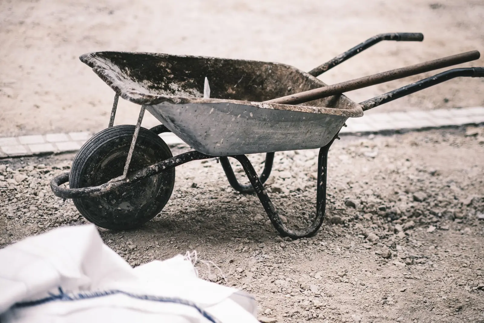 A wheelbarrow standing on freshly dug ground on a building site.