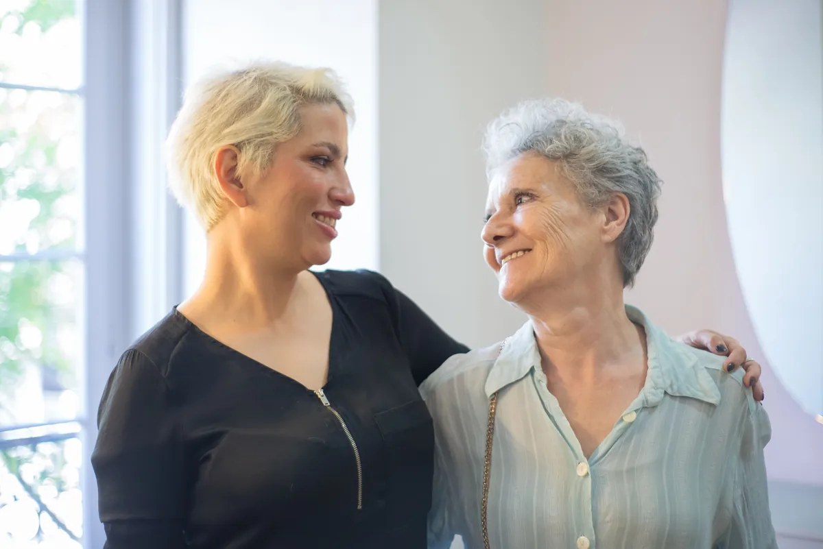 Carol the hairdresser laughing with a resident in the small lounge.