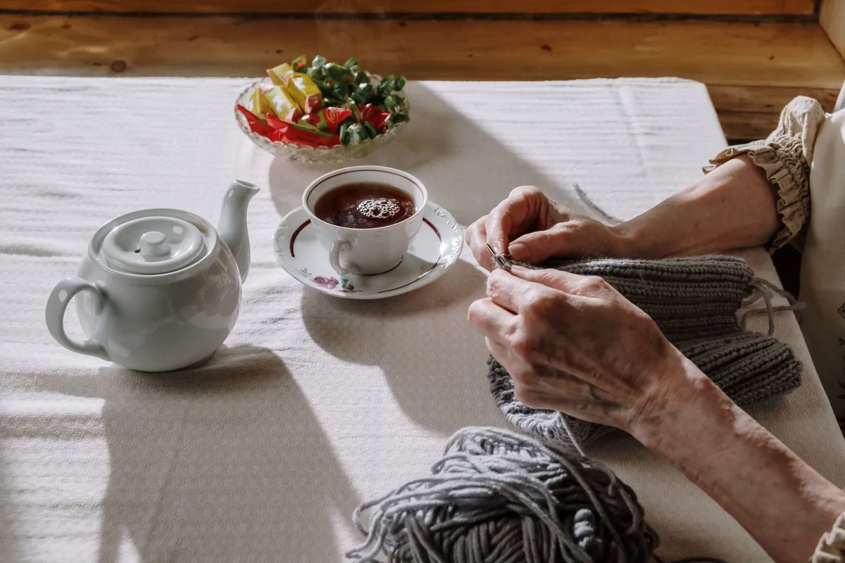 Knitting and a pot of tea on a table in the conservatory.