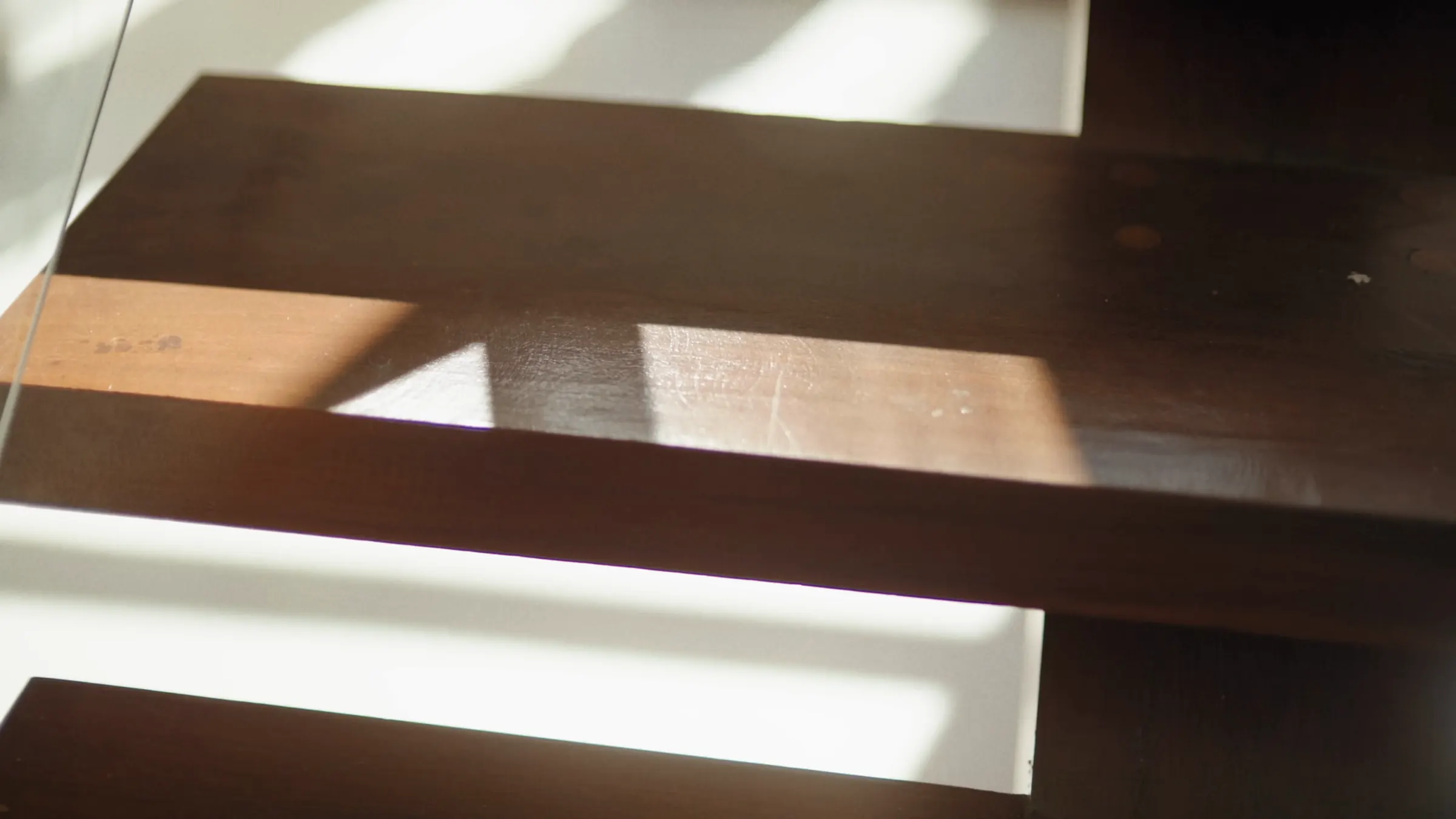 Low morning sun crossing the treads of an oak stair