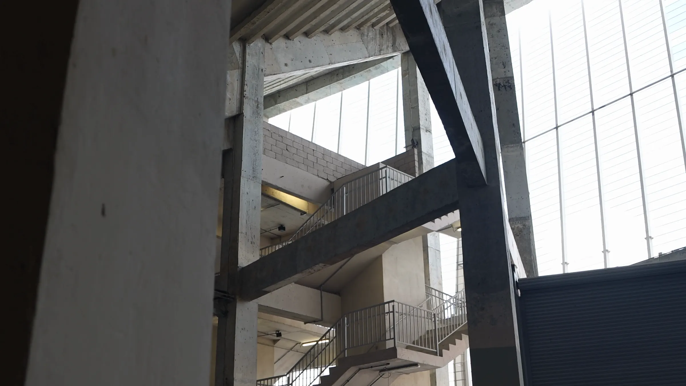 A concrete frame under a glazed roof, seen from below